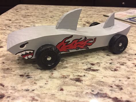 Printable shark pinewood derby car template - 10 Tips for a Fast and Cool Looking Pinewood Derby Car. Bake your block. Max out your weight at the regulation 5 ounces. Use all of the graphite. Sand and polish your wheels and axles. Check alignment. Spend time sanding. Use a high-quality paint. Add decals.